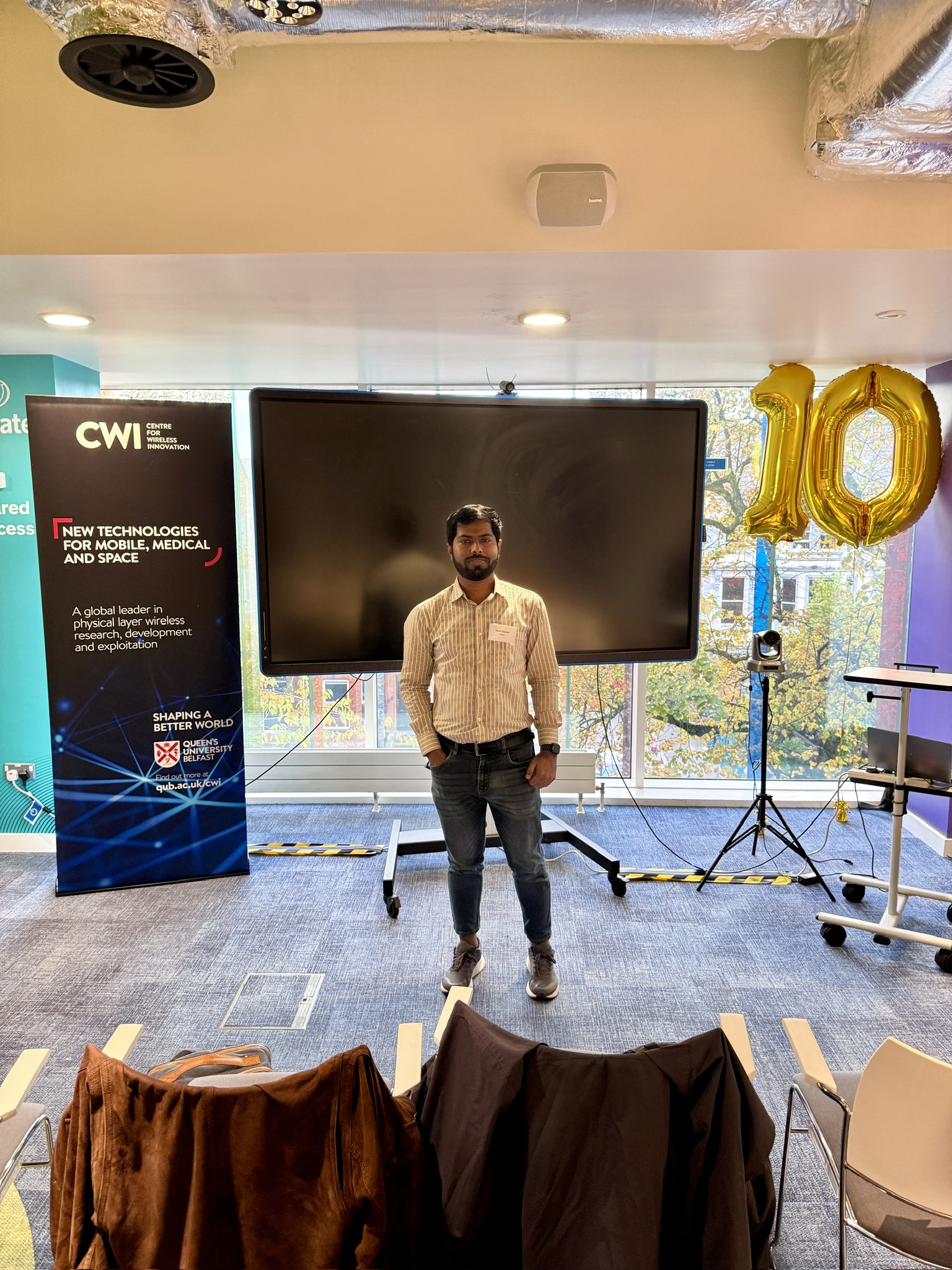 Md Tarek Hassan at the CWI Symposium venue beneath its tenth-anniversary display